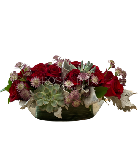Love Boat is a lovely, quaint cluster of roses, succulents, heather and greens in a clear glass boat shaped vase
