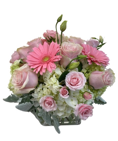 Clear glass cube with  amix of white hydrangea, pink gerberas, and a variety of pink and white flowers