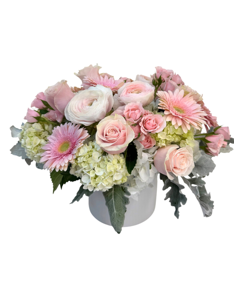 Clear glass cube with  amix of white hydrangea, pink gerberas, and a variety of pink and white flowers
