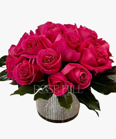 Vase covered in sequin bling filled with bright roses.